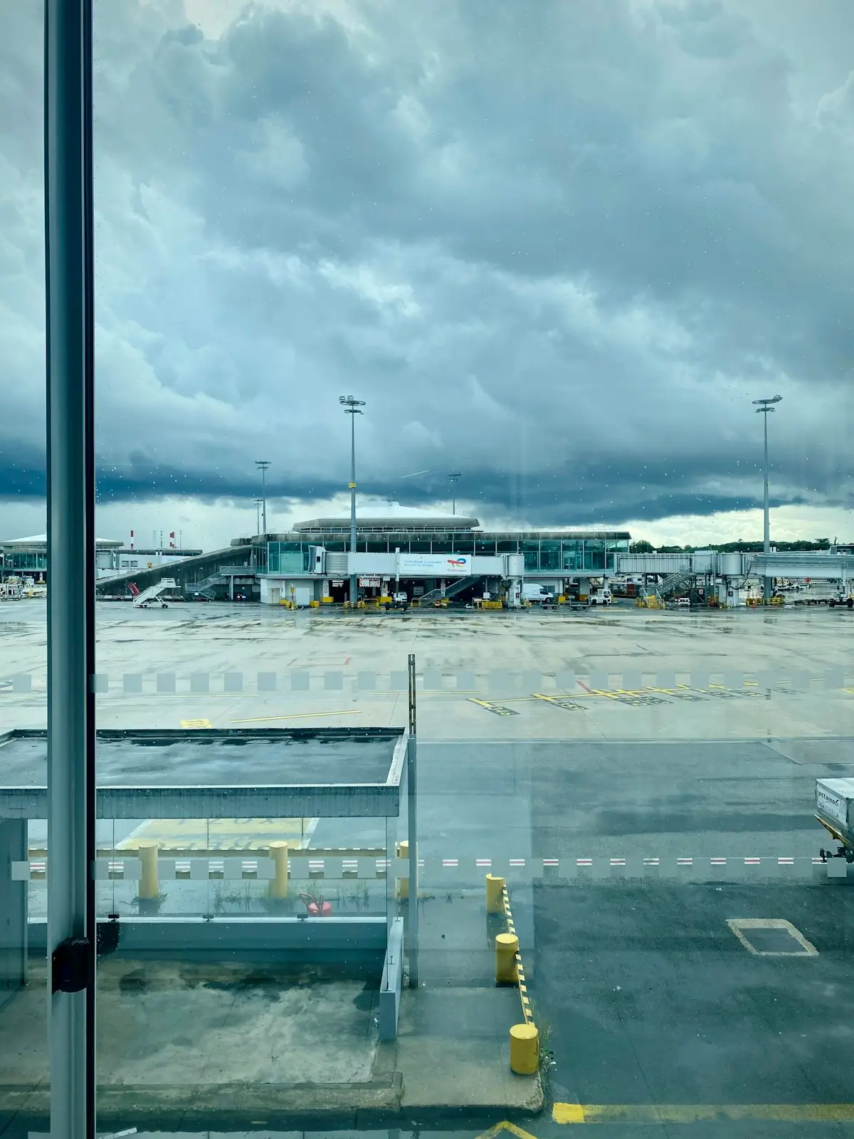 Vue sur les pistes d'un aéroport à travers une baie vitrée